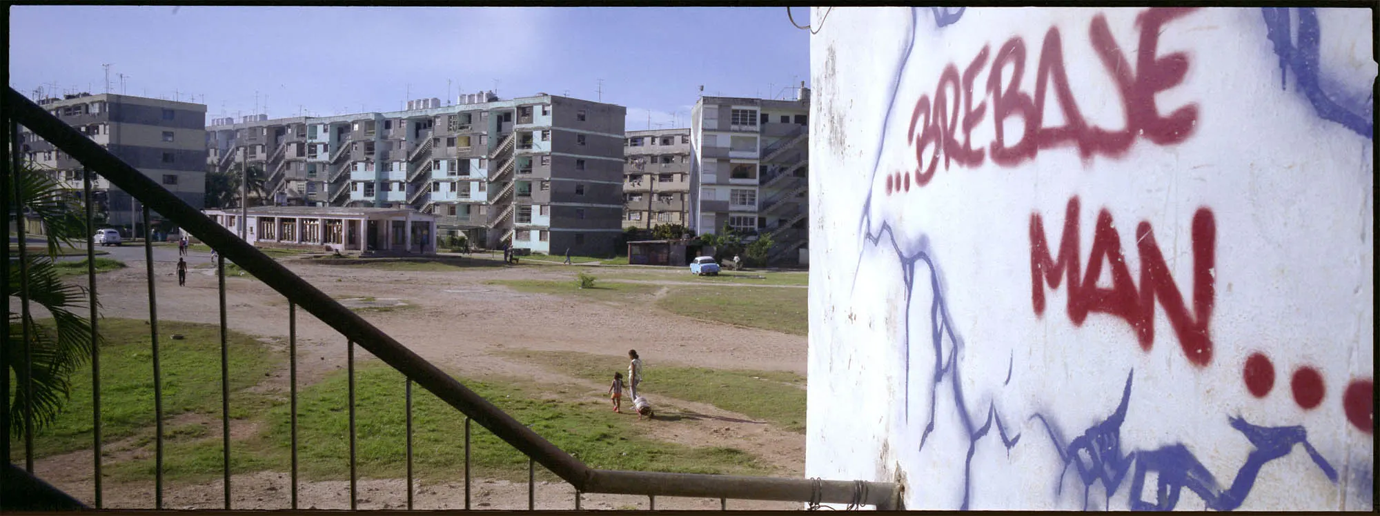 Graffiti that says “...BREBAJE MAN...” on a wall in front of a building.