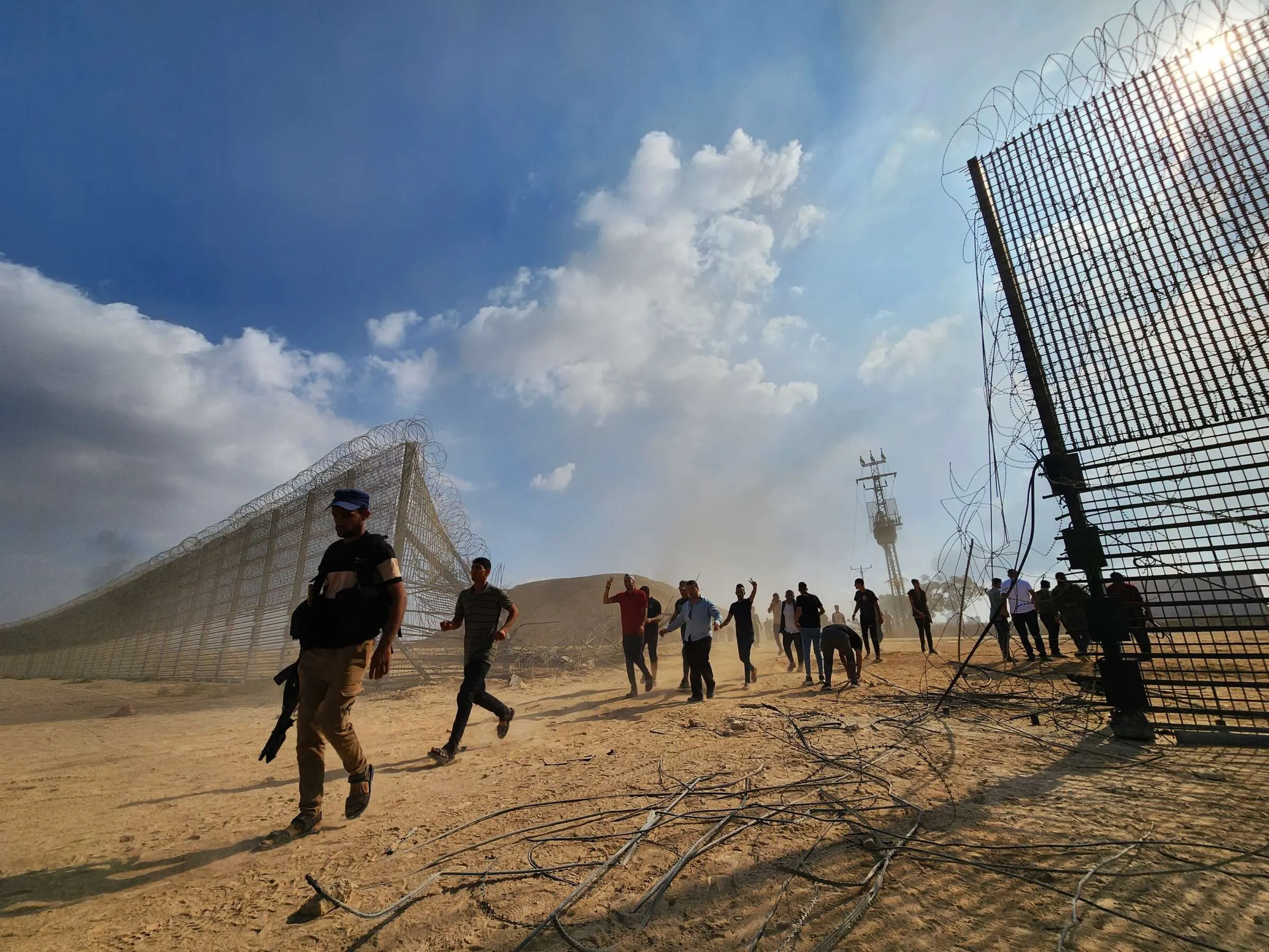 Palestinian resistance fighters enter the Israeli side of the destroyed border fence in Gaza City on 7 October 2023. Copyright: Hani Alshaer / Anadolu Agency via Getty Images.